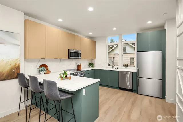a kitchen with refrigerator and chairs