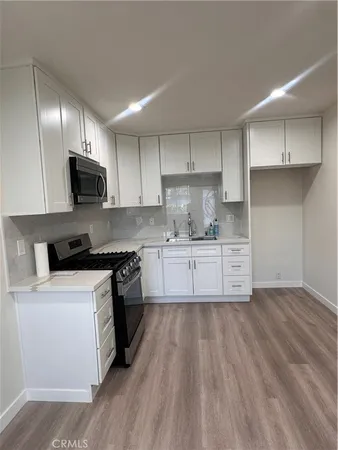 a kitchen with stainless steel appliances granite countertop a stove a sink and a microwave