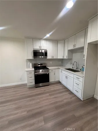 a kitchen with granite countertop white cabinets and stainless steel appliances