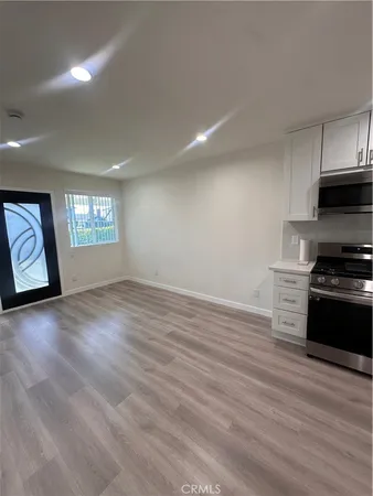 a view of an empty room window and wooden floor