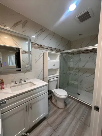a bathroom with a double vanity sink toilet and shower