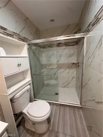 a bathroom with a toilet and a shower