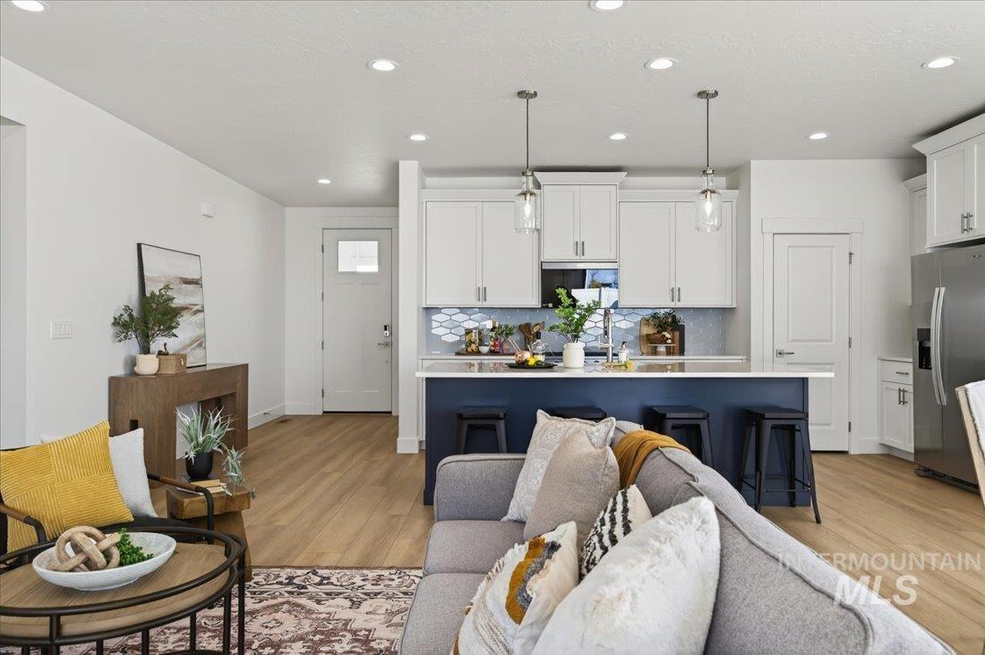 14880 Wing Spread Drive Caldwell, ID 83607 - Photo 2 of 12 Open-concept living area featuring wood-finish flooring, recessed lighting, and a white color palette