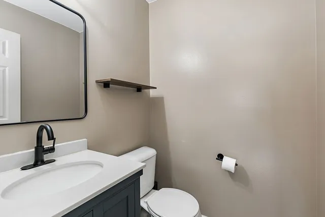 a bathroom with a sink toilet and a mirror