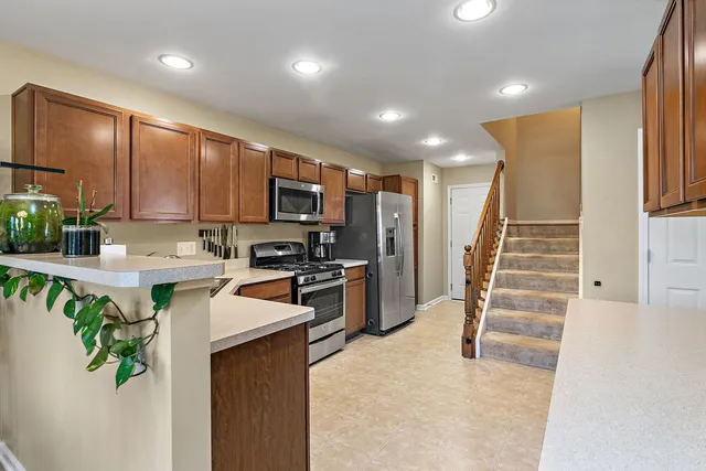 a kitchen with stainless steel appliances granite countertop a refrigerator sink stove microwave and cabinets