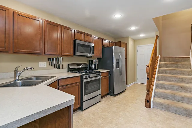 a kitchen with granite countertop a refrigerator stove and sink