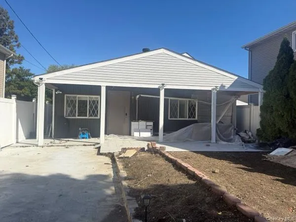 a front view of a house with a yard outdoor seating and garage