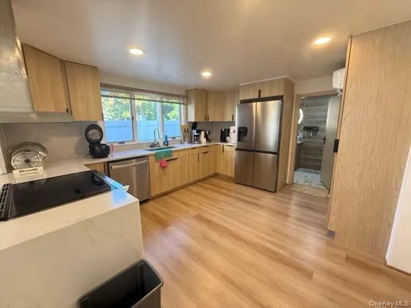 a kitchen with stainless steel appliances granite countertop a refrigerator sink and wooden cabinets