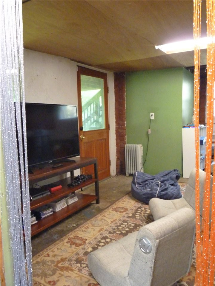 807 West South Street Raleigh, NC 27603 - Photo 24 of 30 Walk out into the backyard from the rec room. You can also access a huge walk-in crawl space from here if you need more storage! Rec Room