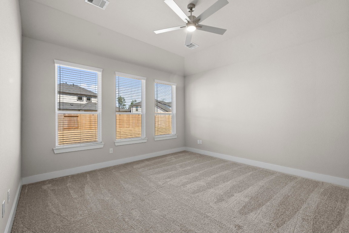 2137 Golden Spruce Court Conroe, TX 77301 - Photo 12 of 41 an empty room with chandelier fan and windows