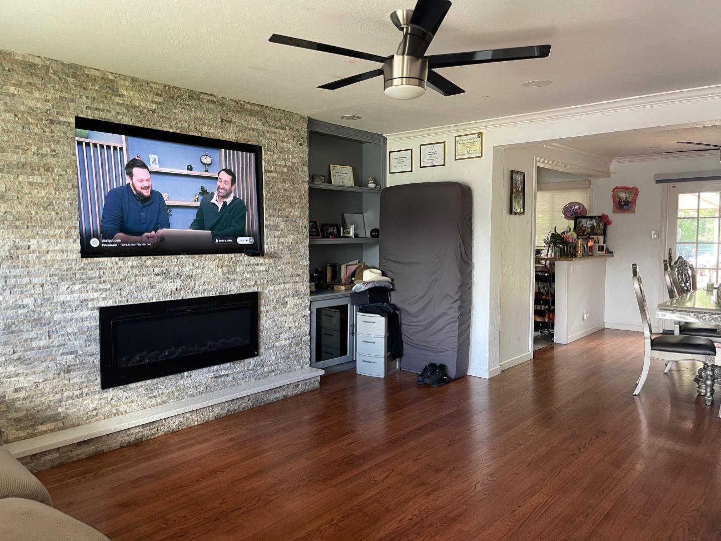 3223 Spring Street Redwood City, CA 94063 - Photo 3 of 14 a living room with furniture a flat screen tv and a fireplace