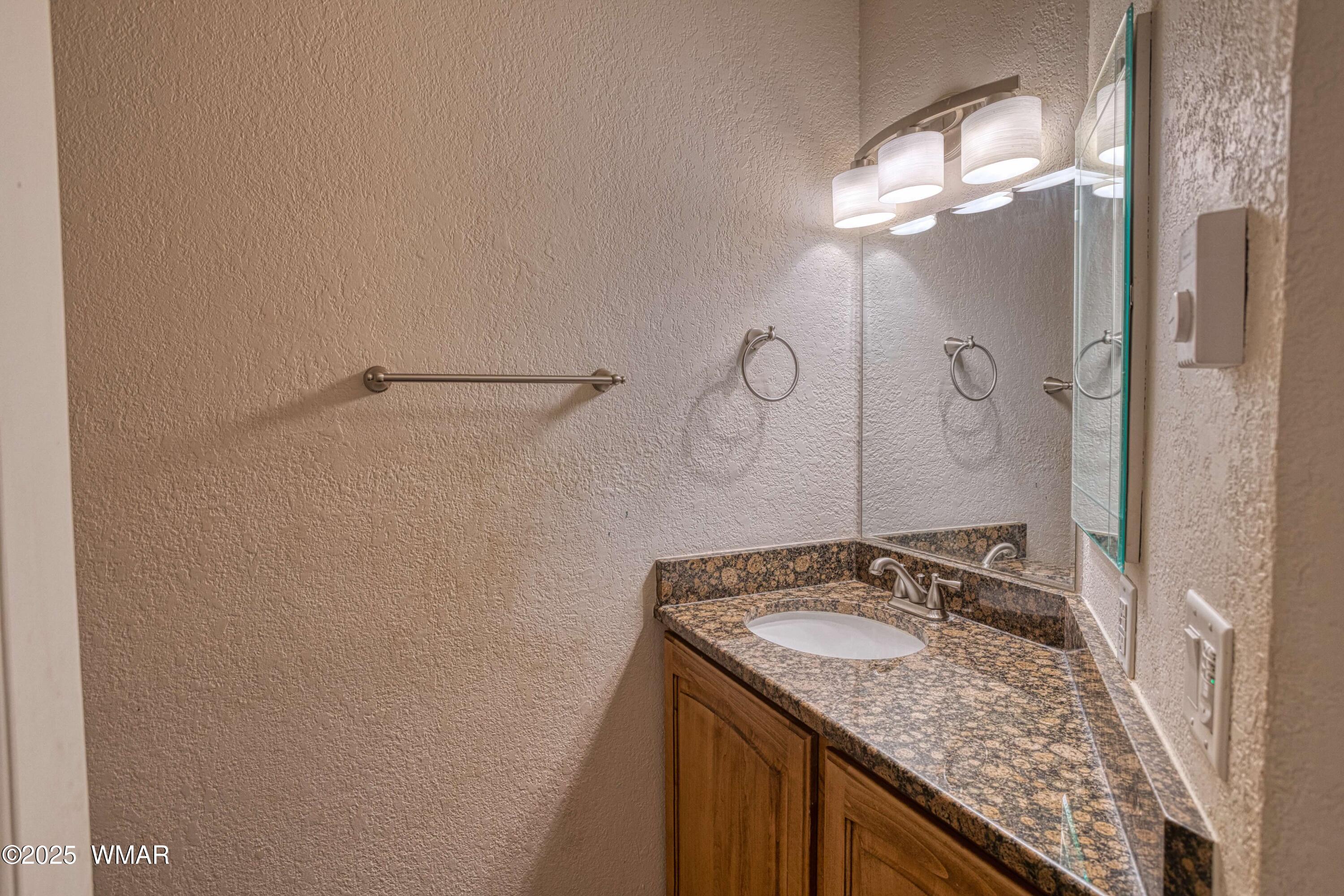2700 South White Mountain Road, Unit 122 Show Low, AZ 85901 - Photo 13 of 25 a bathroom with a granite countertop sink and a mirror