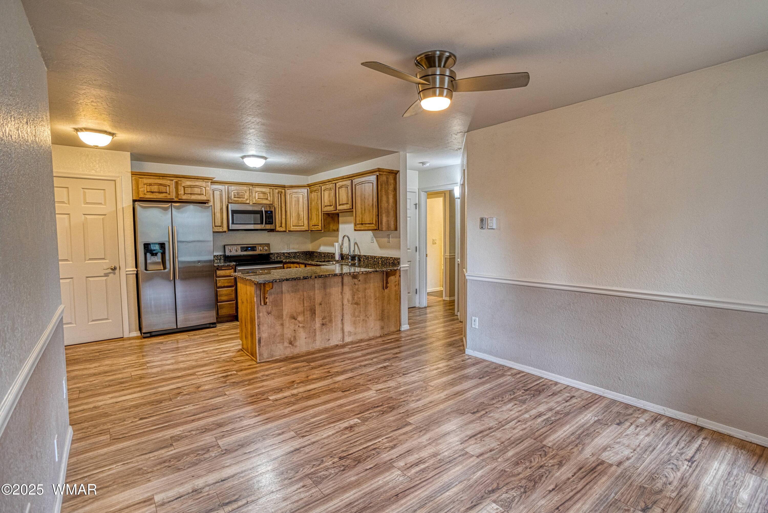 2700 South White Mountain Road, Unit 122 Show Low, AZ 85901 - Photo 4 of 25 a kitchen with stainless steel appliances a refrigerator and a stove top oven
