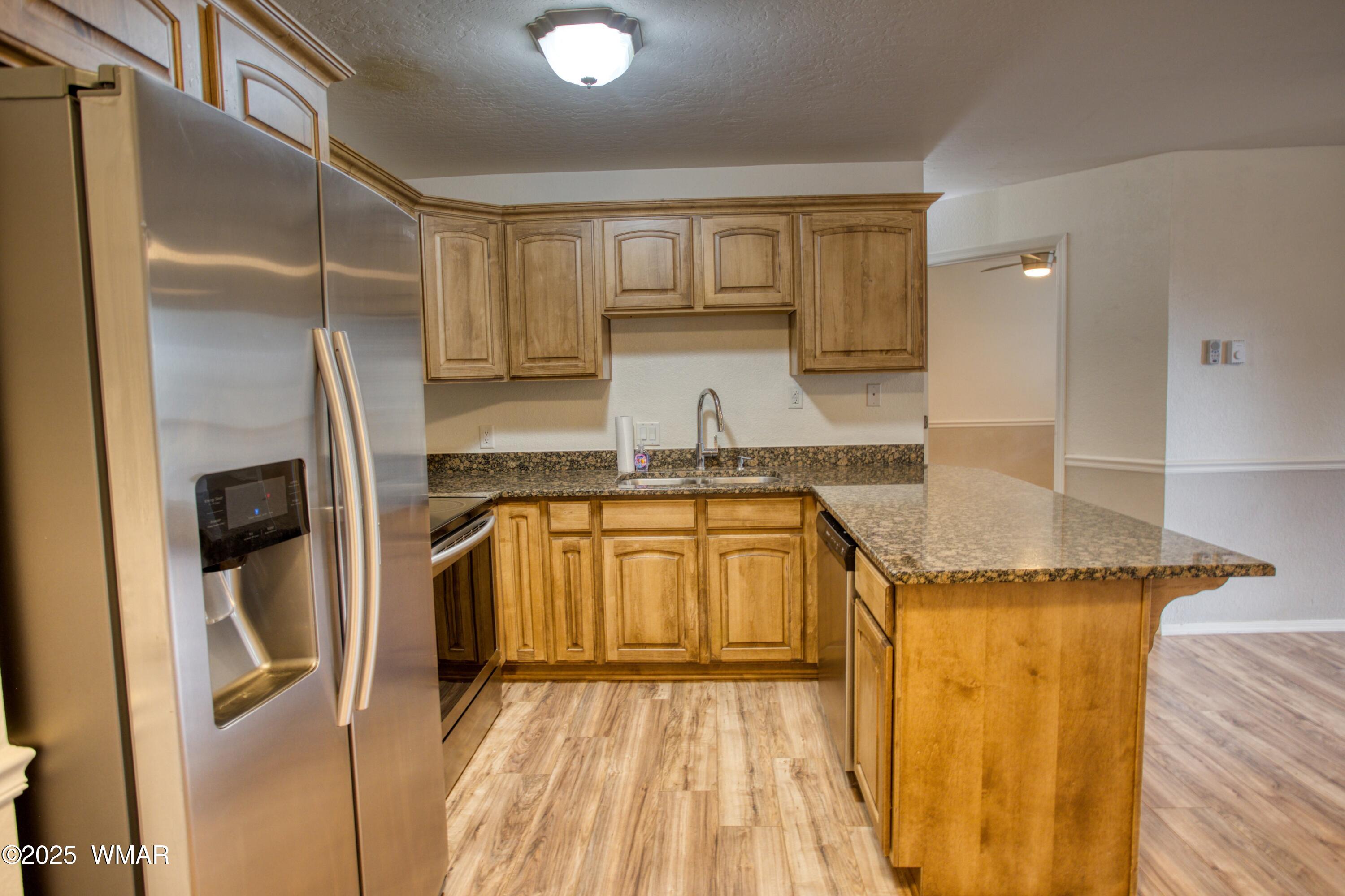 2700 South White Mountain Road, Unit 122 Show Low, AZ 85901 - Photo 7 of 25 a kitchen with a refrigerator a sink and cabinets
