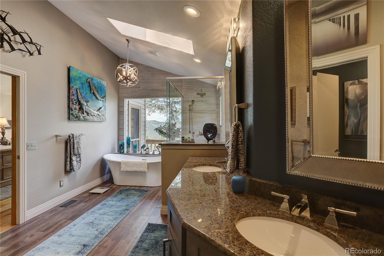 23072 Pinecrest Road Golden, CO 80401 - Photo 22 of 34 a bathroom with double vanity sinks a mirror and a shower