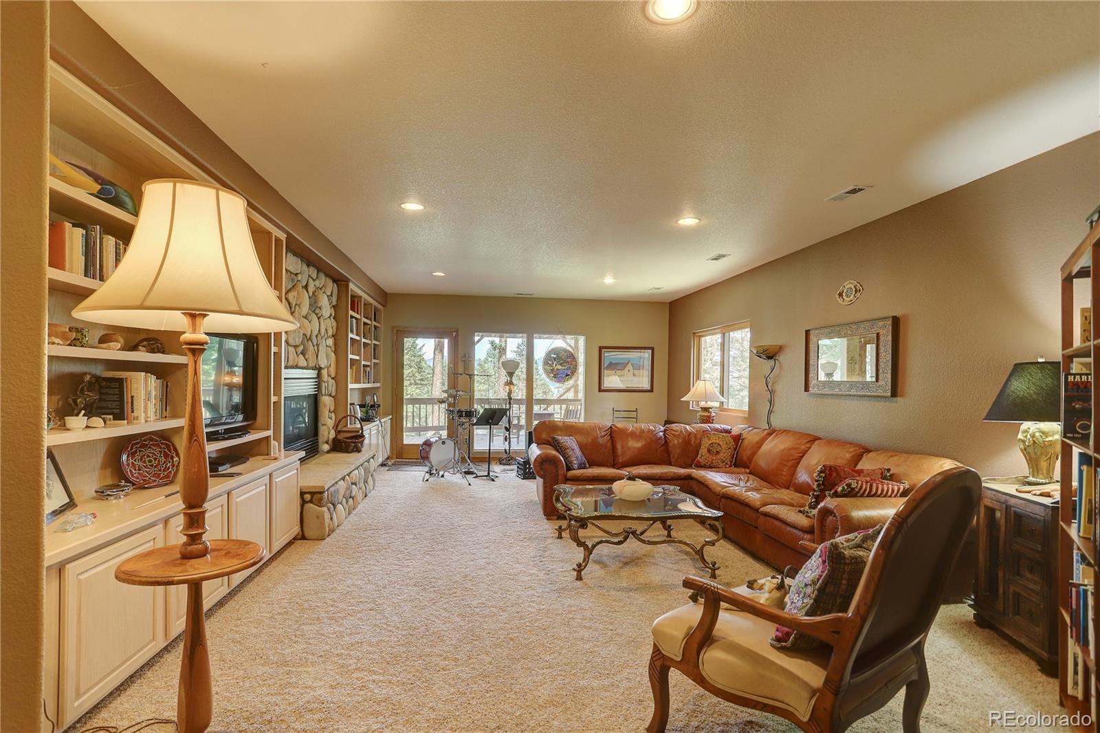 23072 Pinecrest Road Golden, CO 80401 - Photo 29 of 34 a living room with furniture a flat screen tv and a large window