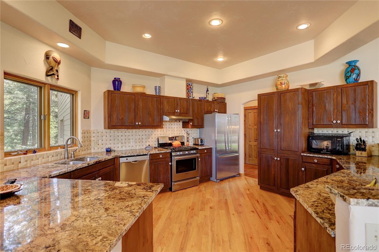 23072 Pinecrest Road Golden, CO 80401 - Photo 7 of 34 a kitchen with stainless steel appliances granite countertop a refrigerator stove and sink