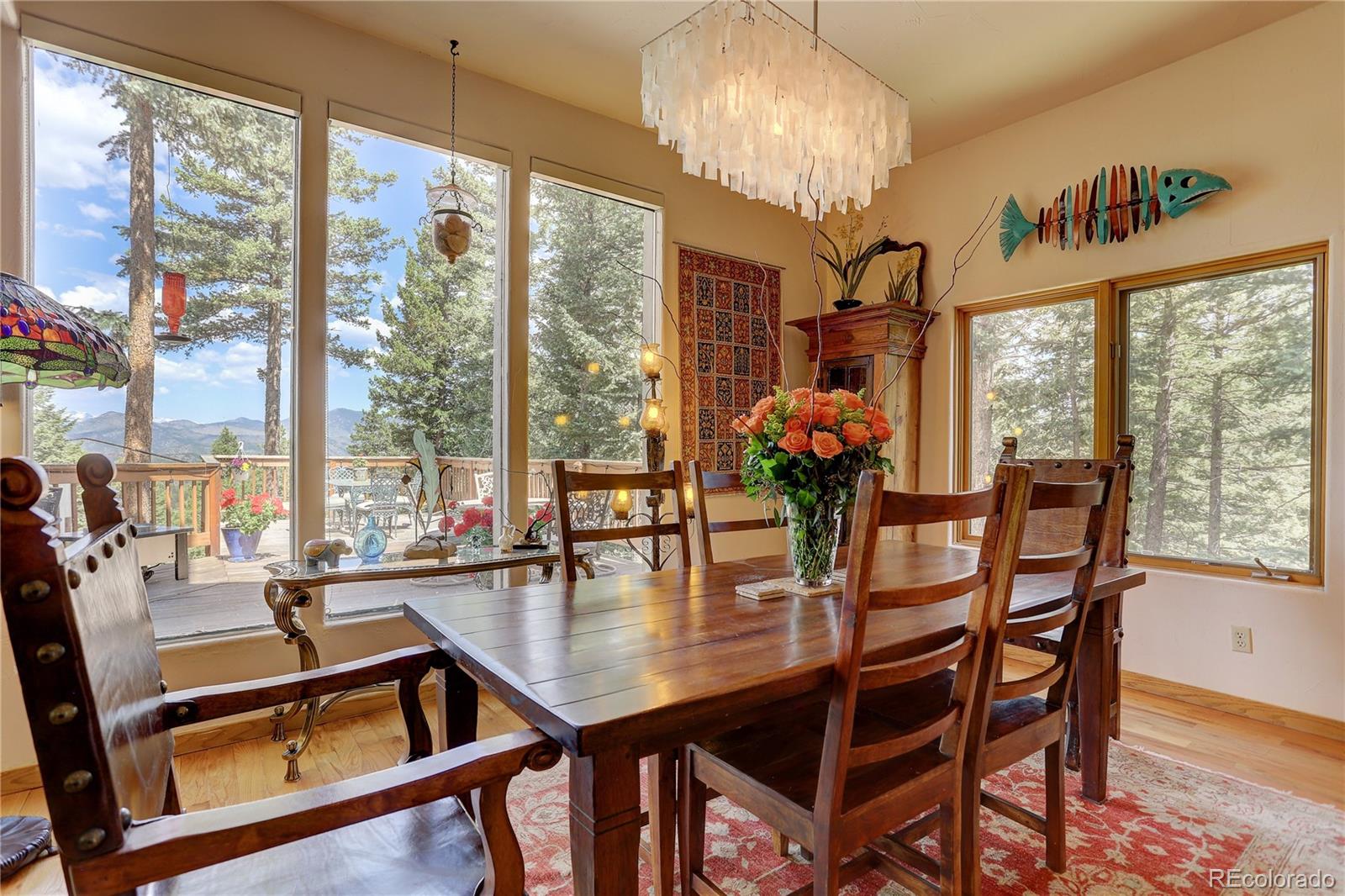 23072 Pinecrest Road Golden, CO 80401 - Photo 9 of 34 a dining room with furniture a chandelier and wooden floor