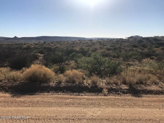 a view of a field with mountains in the background
