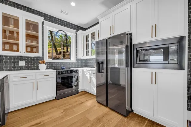 a kitchen with white cabinets and window