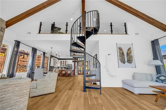 a living room with couches chairs and closet with wooden floor
