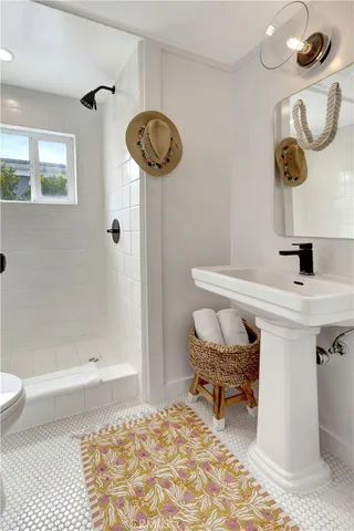 a bathroom with a sink a toilet and shower