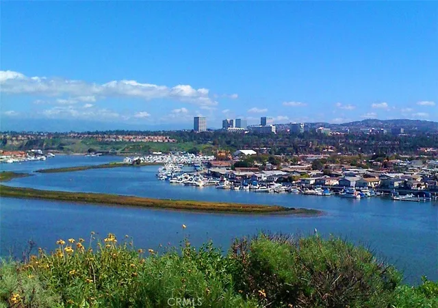 a view of a city with lots of residential buildings ocean and mountain view in back