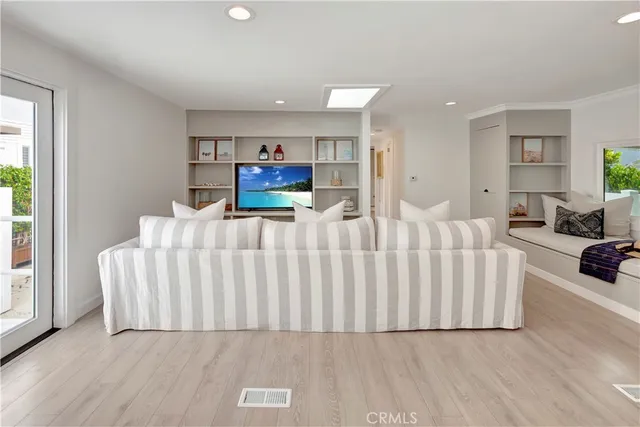 a living room with furniture a flat screen tv and a table