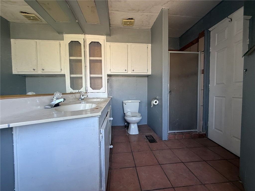 1629 Ramar Road Bullhead City, AZ 86442 - Photo 15 of 29 Full bathroom featuring vanity, a shower stall, and dark tile patterned floors