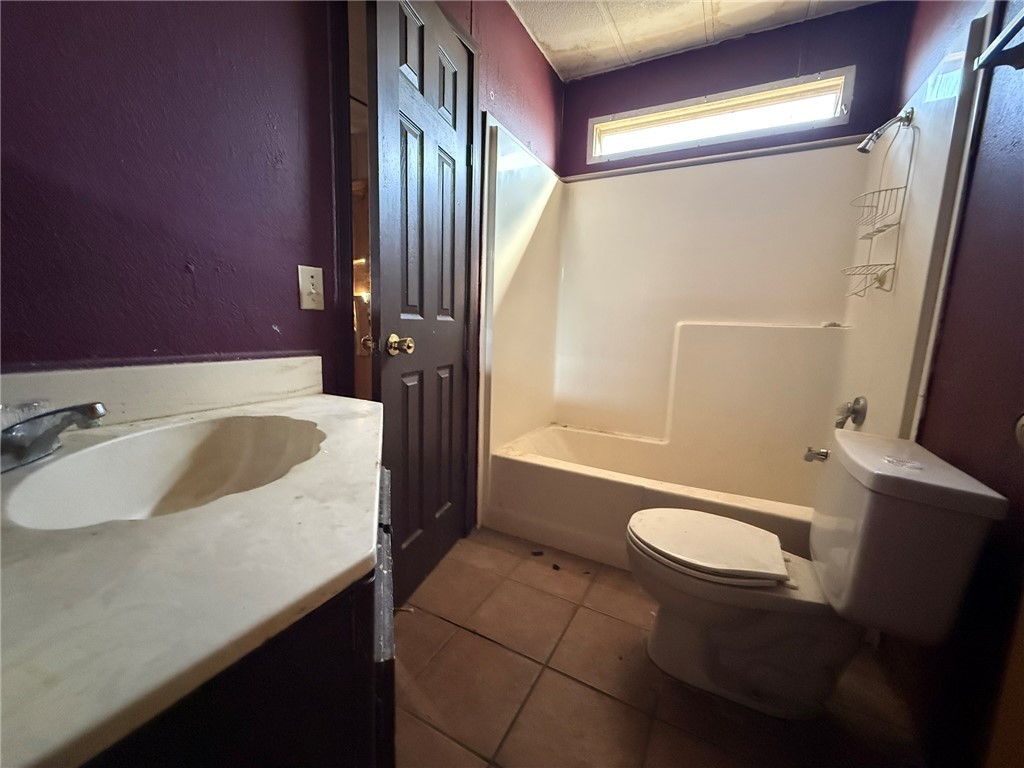 1629 Ramar Road Bullhead City, AZ 86442 - Photo 22 of 29 Bathroom with vanity, bathtub / shower combination, dark tile patterned flooring, and a textured wall