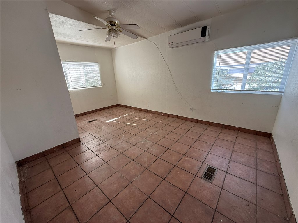 1629 Ramar Road Bullhead City, AZ 86442 - Photo 25 of 29 Tiled spare room with an AC wall unit and a ceiling fan