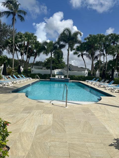 3209 Clint Moore Road, Unit 202 Boca Raton, FL 33496 - Photo 18 of 24 a view of a swimming pool with a yard