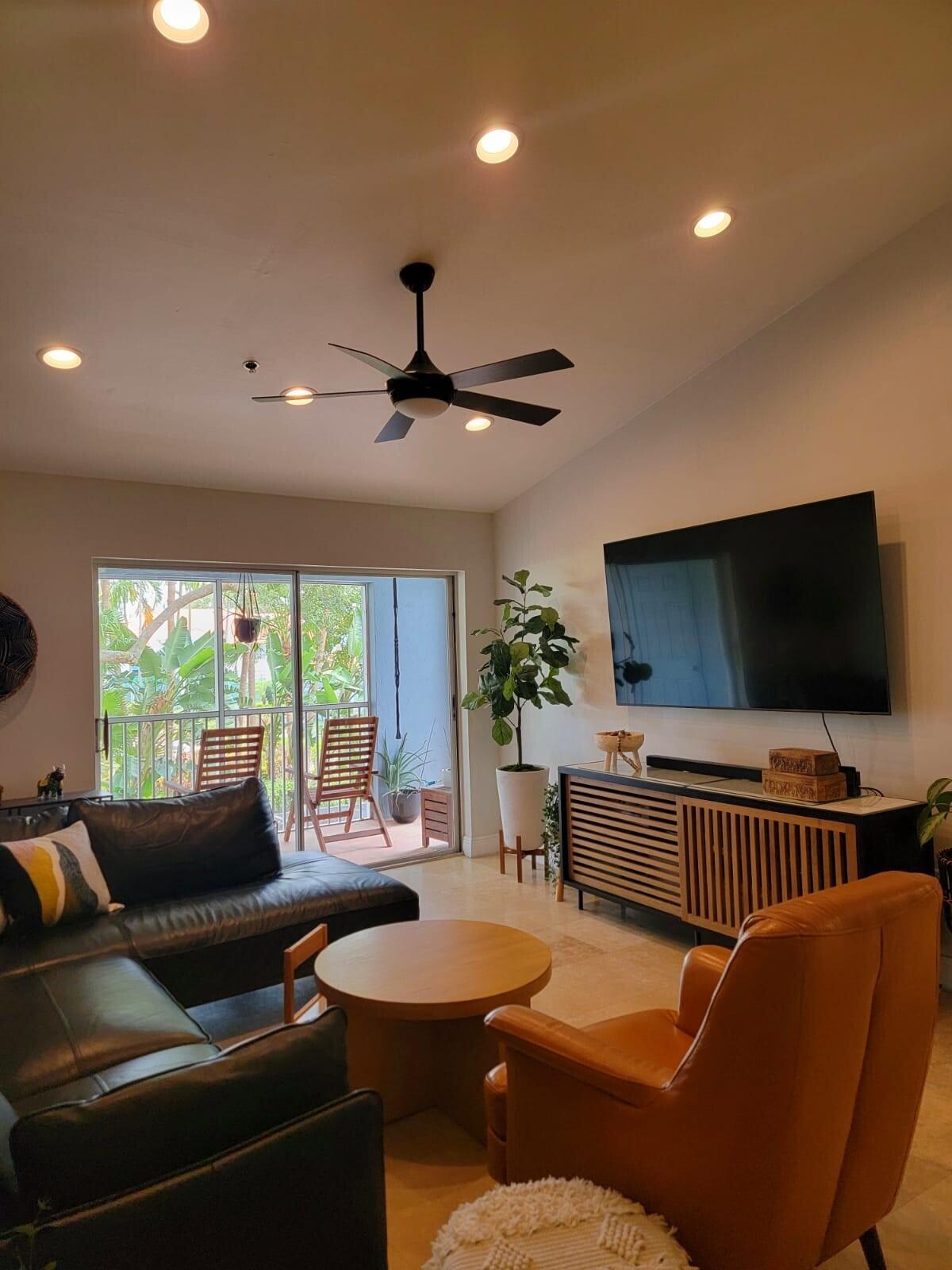 3209 Clint Moore Road, Unit 202 Boca Raton, FL 33496 - Photo 5 of 24 a living room with furniture and a flat screen tv