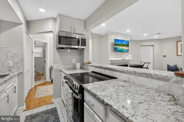 a kitchen with stainless steel appliances granite countertop a sink and a stove