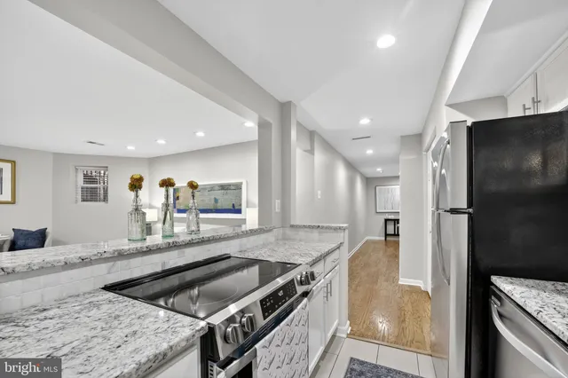 a kitchen with stainless steel appliances granite countertop a sink and a refrigerator