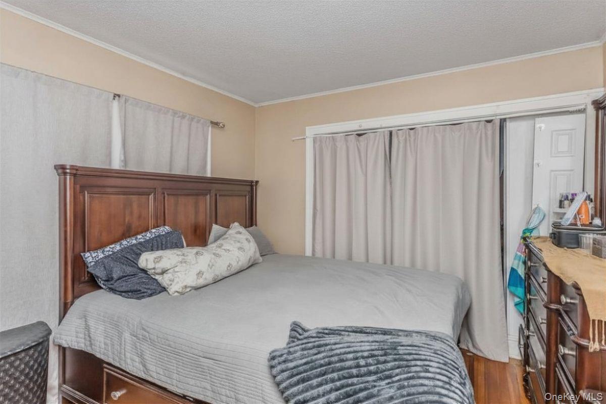 237 Rhodes Avenue Hempstead, NY 11550 - Photo 12 of 24 a bedroom with a bed and a window