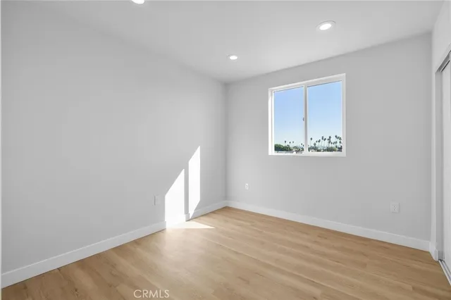 an empty room with wooden floor and window