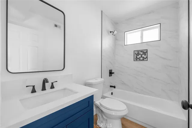 a bathroom with a sink toilet a mirror and shower