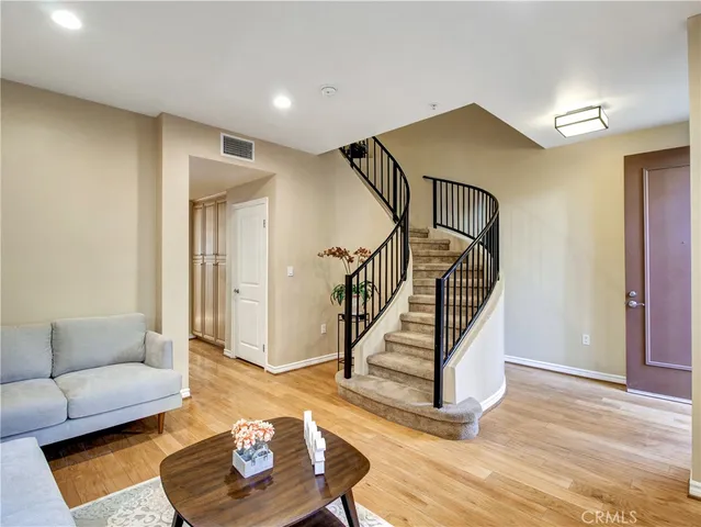 a living room with wooden floor and a ceiling fan