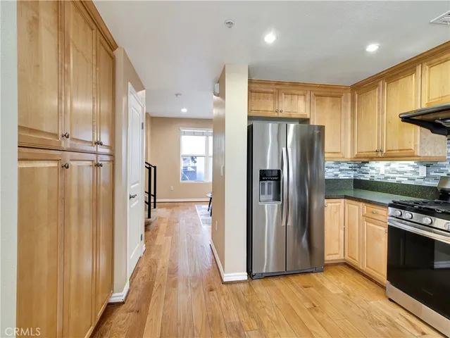 a view of a kitchen with wooden floor electronic appliances and furniture