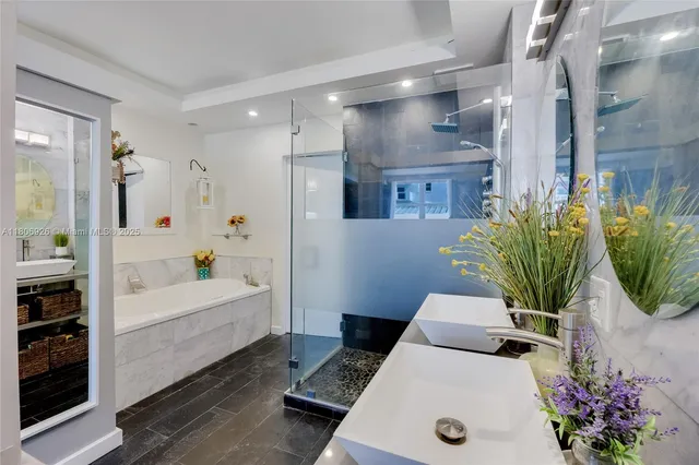 a bathroom with a tub a potted plant and a sink