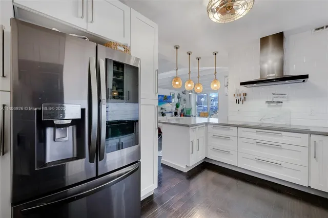 a kitchen with granite countertop white cabinets and stainless steel appliances