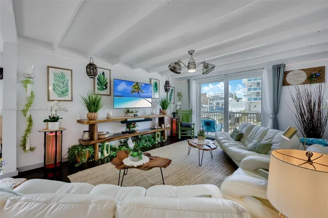 a living room with furniture a flat screen tv and a floor to ceiling window