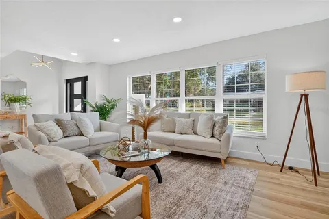 a living room with furniture and a wooden floor