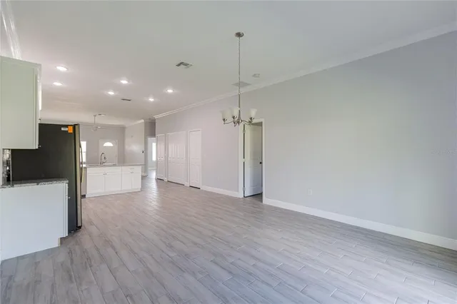 a view of a big room with wooden floor and windows