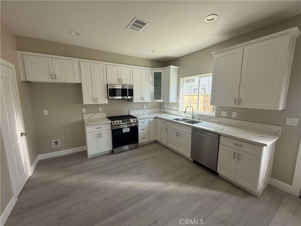 15909 Merrill Avenue, Unit 9 Fontana, CA 92335 - Photo 3 of 19 a kitchen with stainless steel appliances granite countertop a stove sink and cabinets