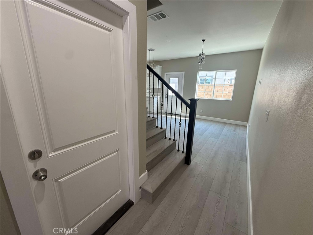 15909 Merrill Avenue, Unit 9 Fontana, CA 92335 - Photo 6 of 19 a view of a hallway with wooden floor and staircase