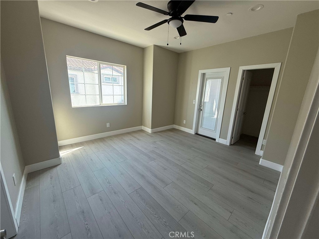15909 Merrill Avenue, Unit 9 Fontana, CA 92335 - Photo 8 of 19 a view of an empty room with wooden floor and a window