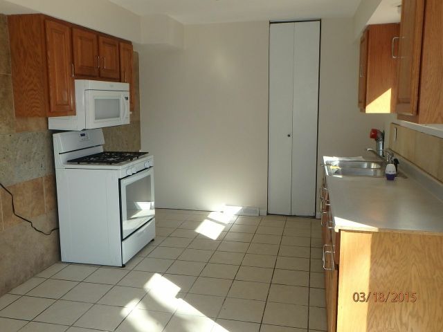 15231 Millard Avenue Midlothian, IL 60445 - Photo 4 of 15 a kitchen with granite countertop a stove a sink and a microwave