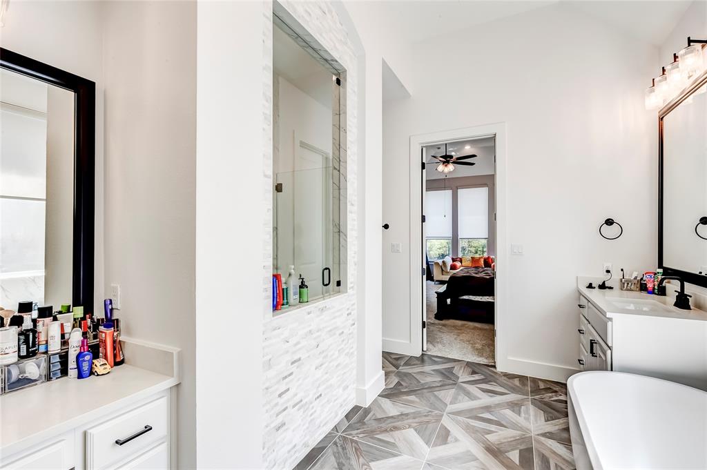 126 LITTLE Strm Cove Austin, TX 78737 - Photo 27 of 40 Luxurious master bath with striking tiled flooring and sleek fixtures offers a seamless transition to the inviting primary bedroom.